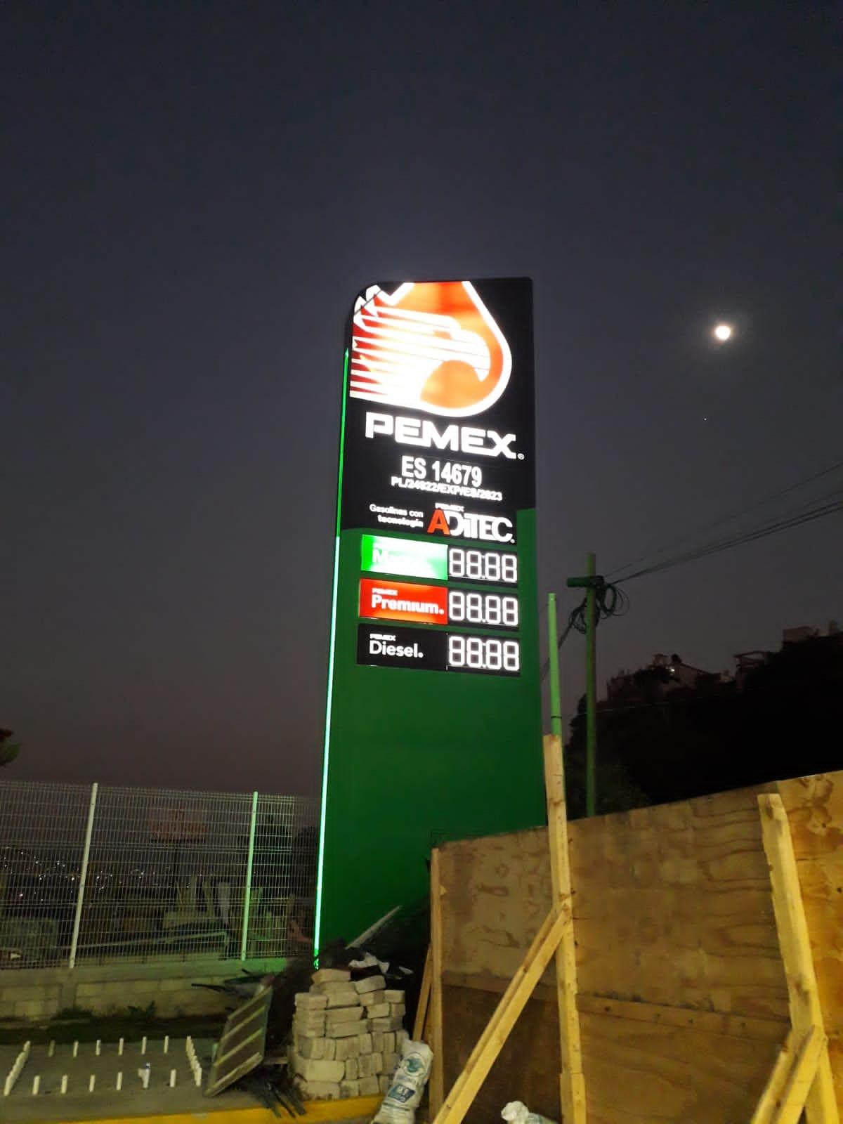 Anuncio unipolar de precios iluminado de noche