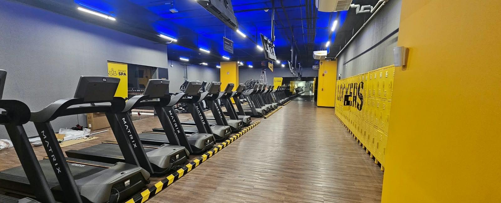 Zona de cardio con caminadoras y lockers del gimnasio Smart Fit